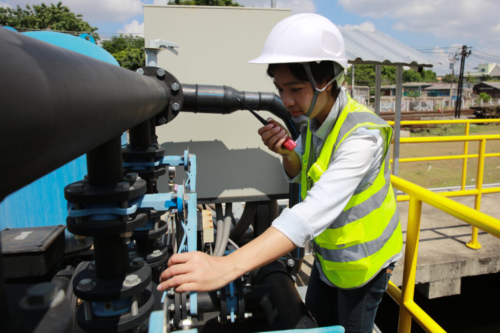 Young female engineer check water pump and water treatment system, industrial and factory concept